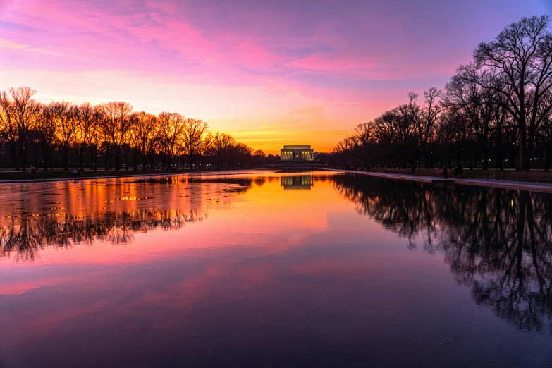 a colorful sunset reflects in a canal in this scenic view