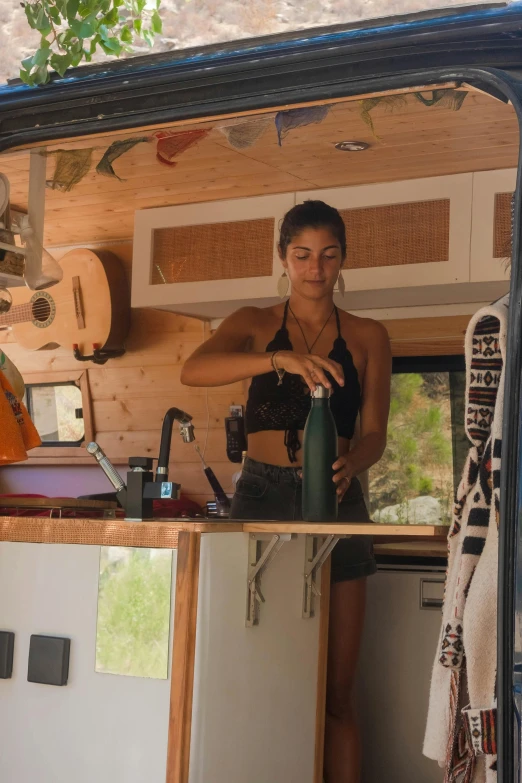 a woman standing in the kitchen of a small rv