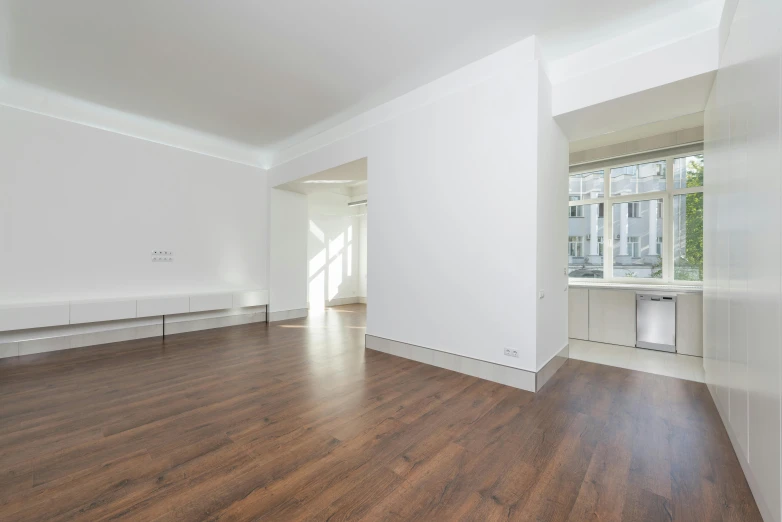 an empty living room with wood floors and white walls