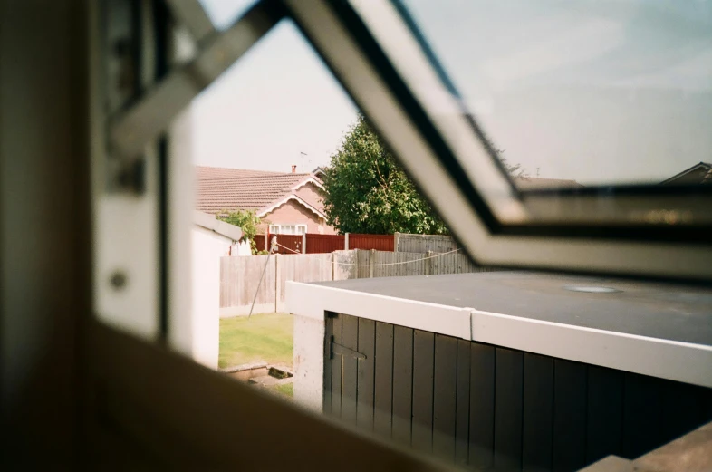 an open window showing a house and a yard