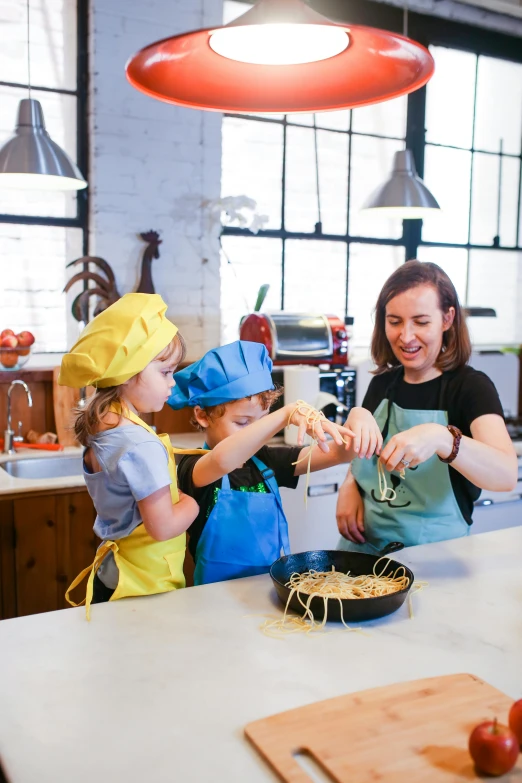 three children making sandwiches in kitchen with adult