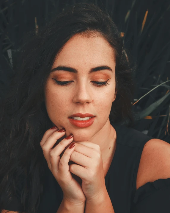 a woman holding her hands near her face