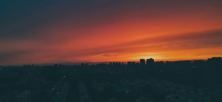 an orange and black sky with a sun setting in the distance