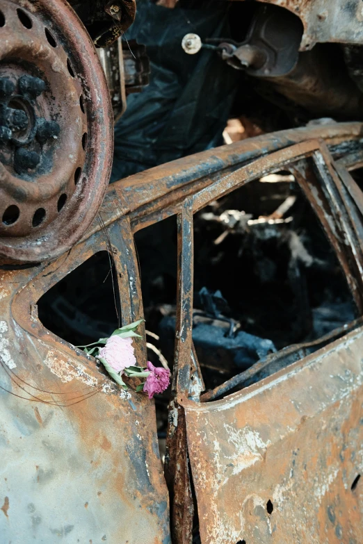 there is a broken car that has flowers on it