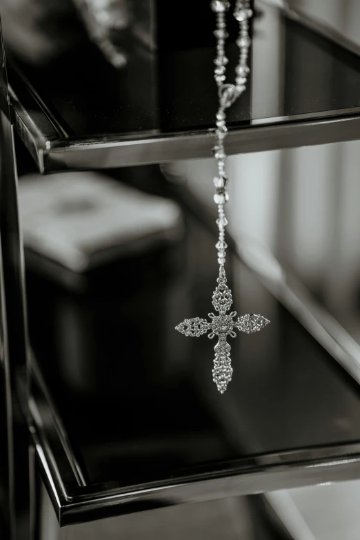 a rosary hanging on top of a glass table