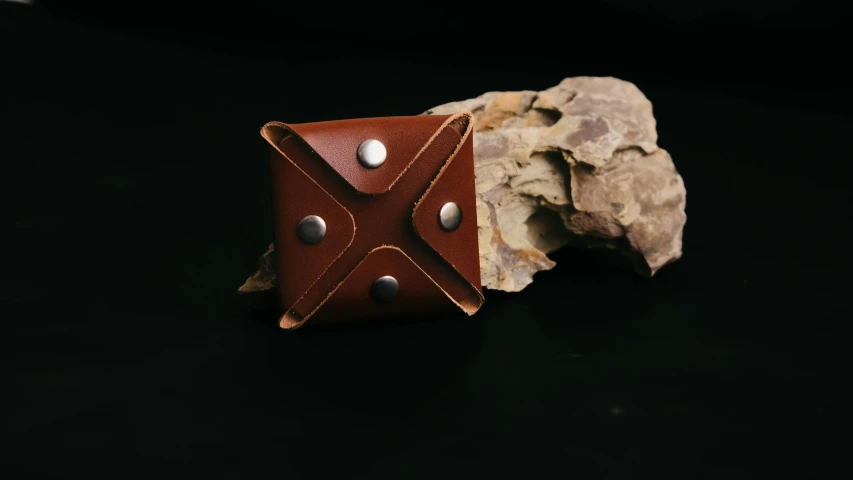 a piece of leather sitting on top of a rock