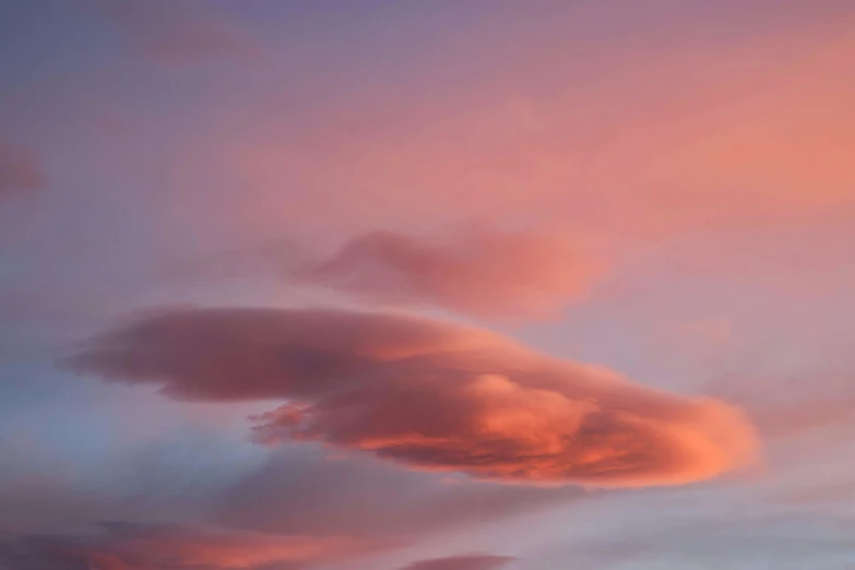 an orange cloud is in the middle of a purple sky