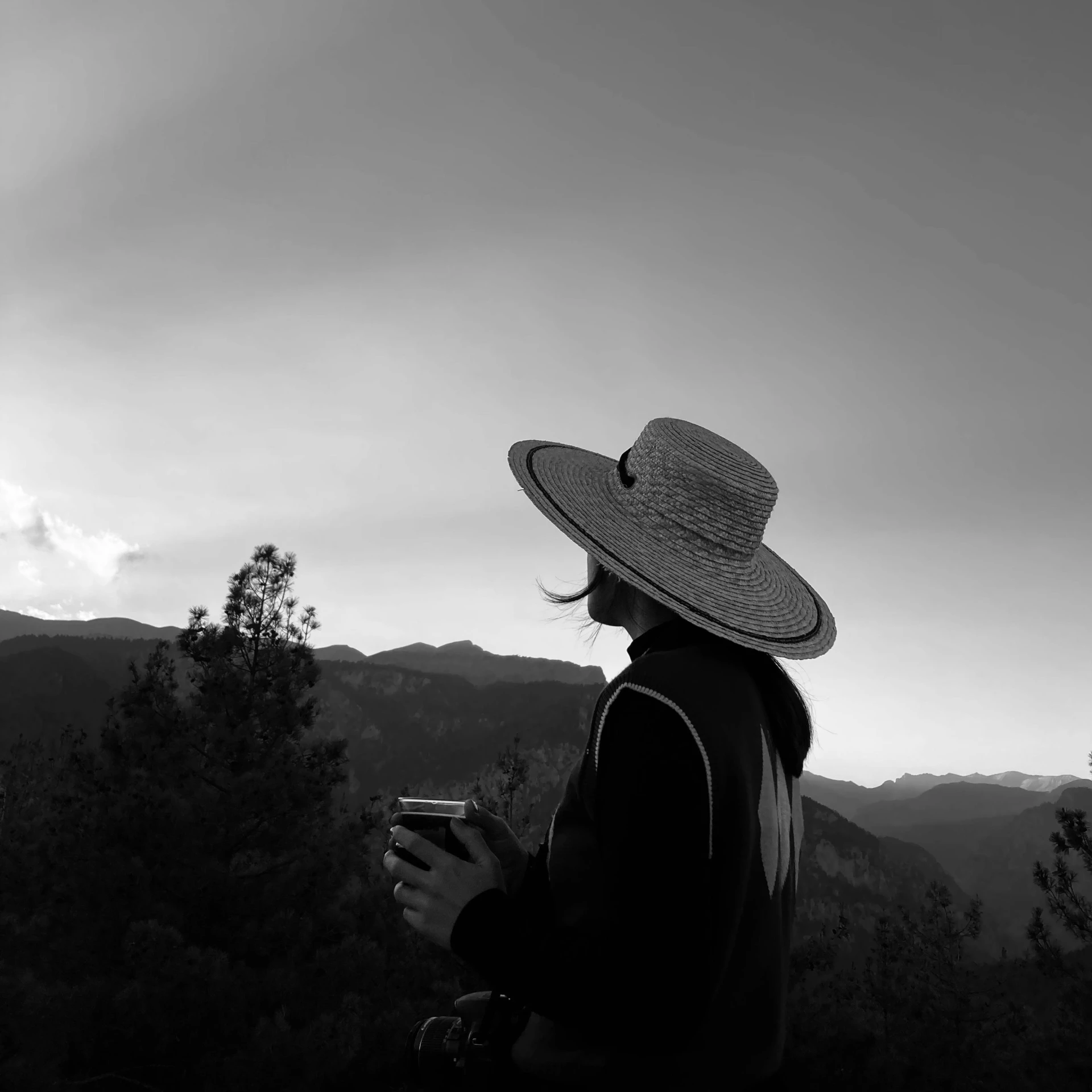 black and white po of woman wearing hat looking up at the sky