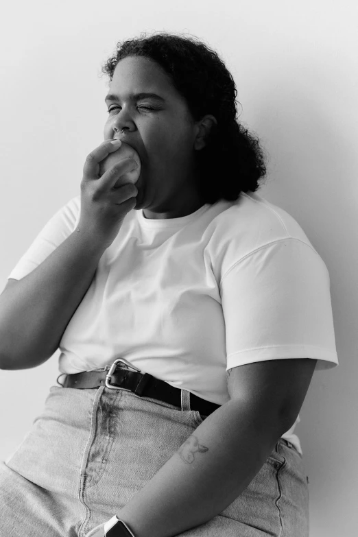 a woman sitting and eating food looking at camera