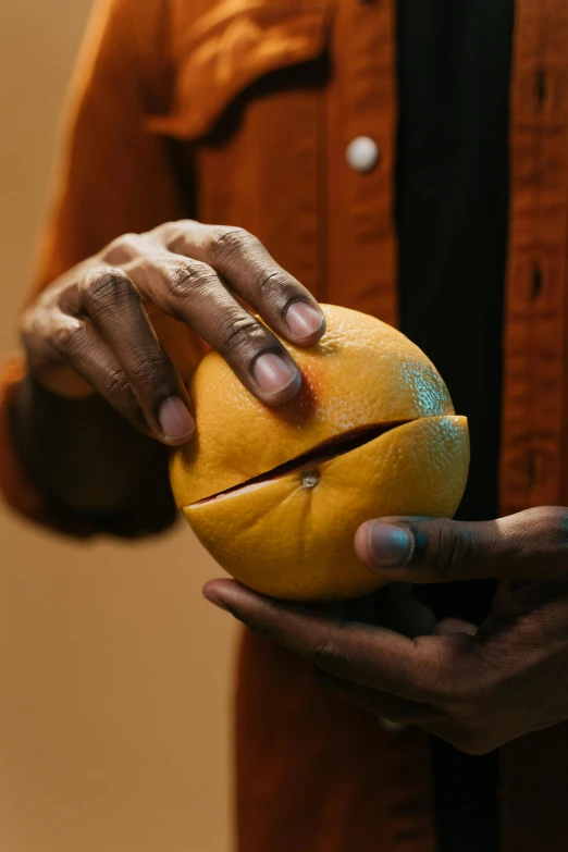 a person that is holding an orange in their hands