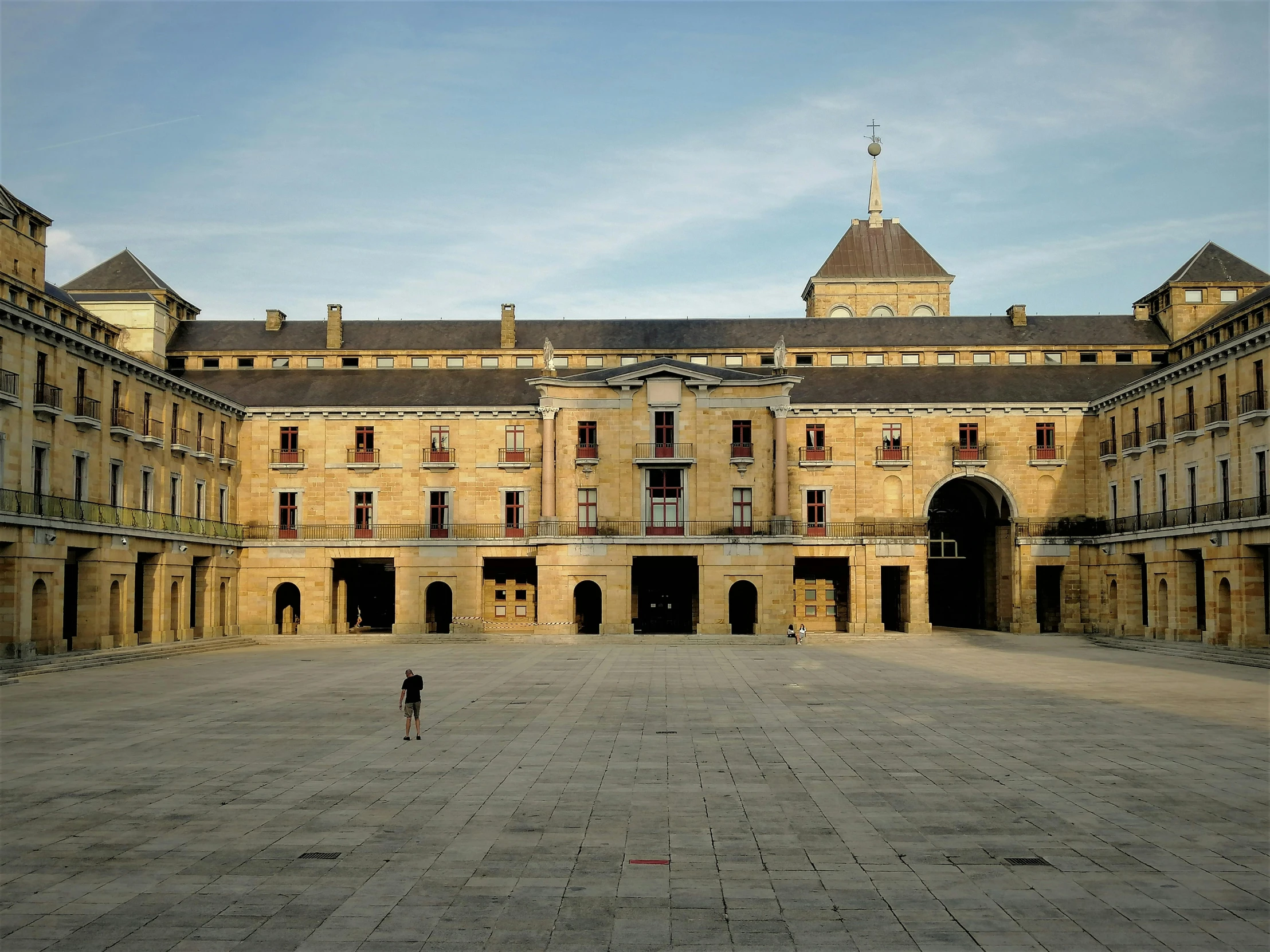 a large building with columns, an entrance, and a courtyard