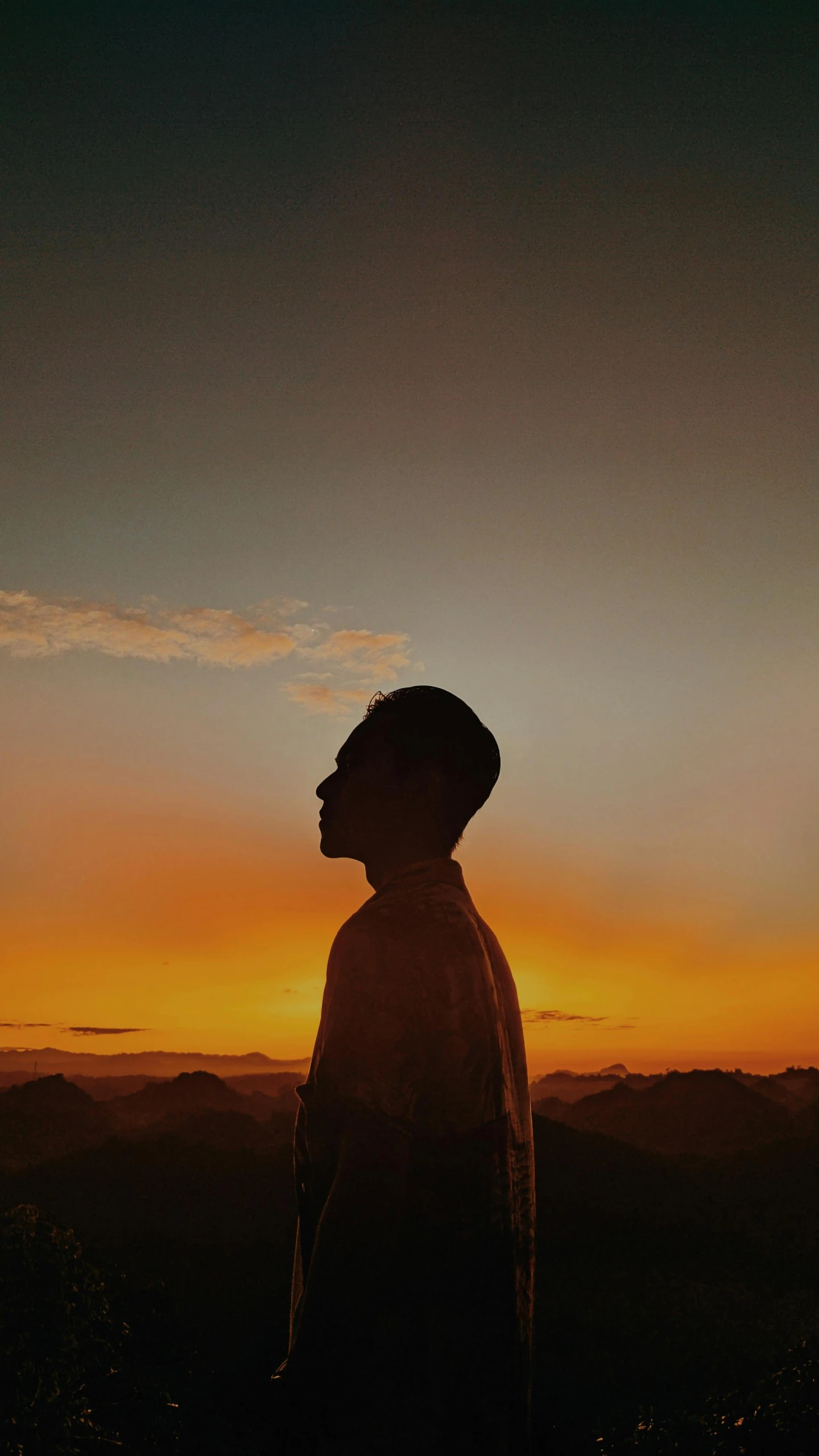 a man standing in the mountains looking into the distance