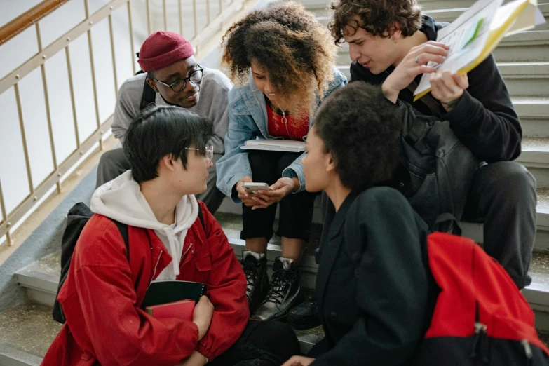 a group of young people sit on steps next to each other