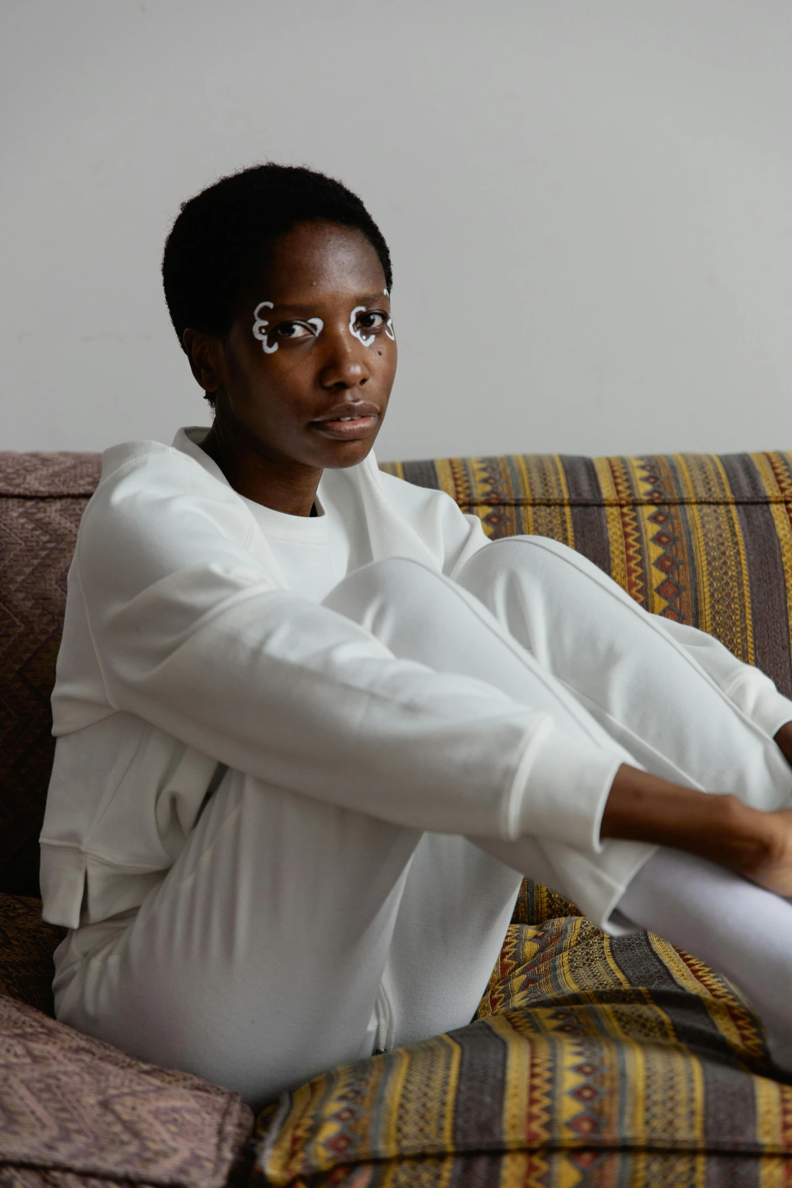 a woman sitting on a sofa next to a remote