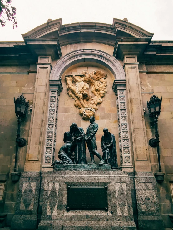 two statues are shown against a large stone structure