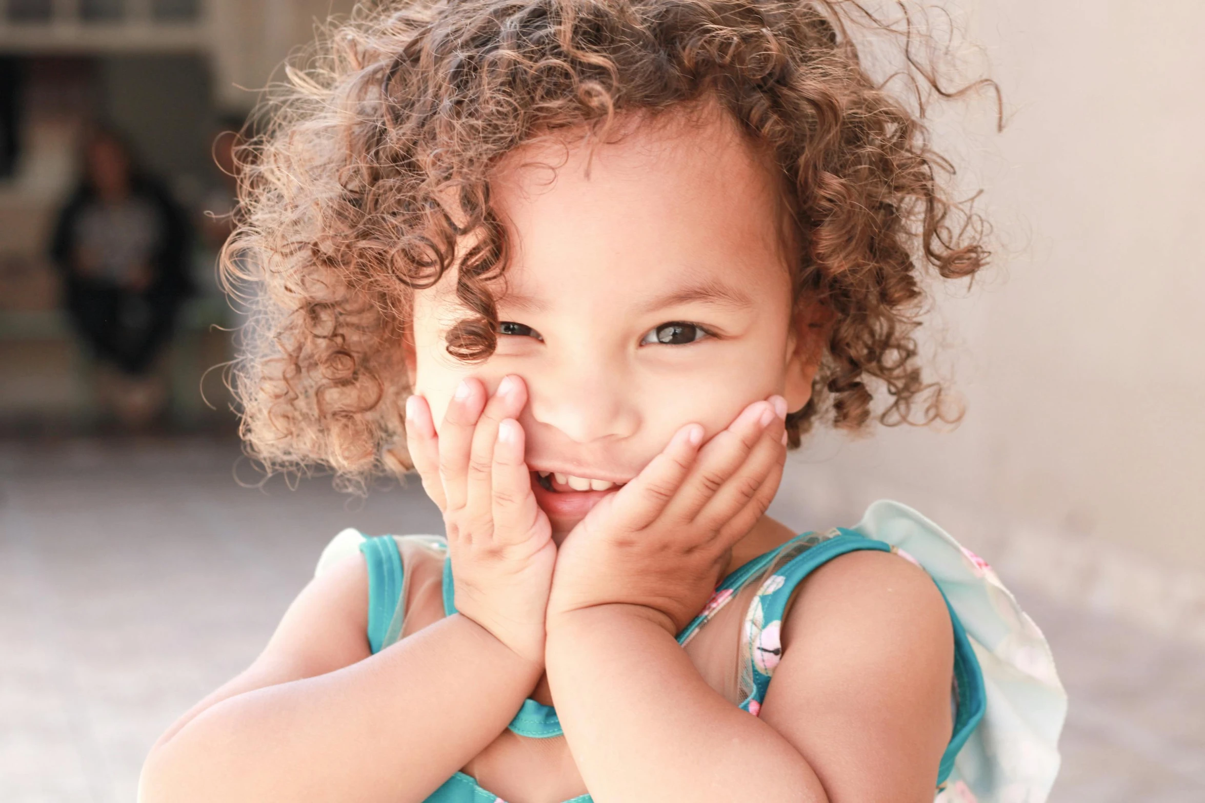 a girl wearing blue dress with hands to her face