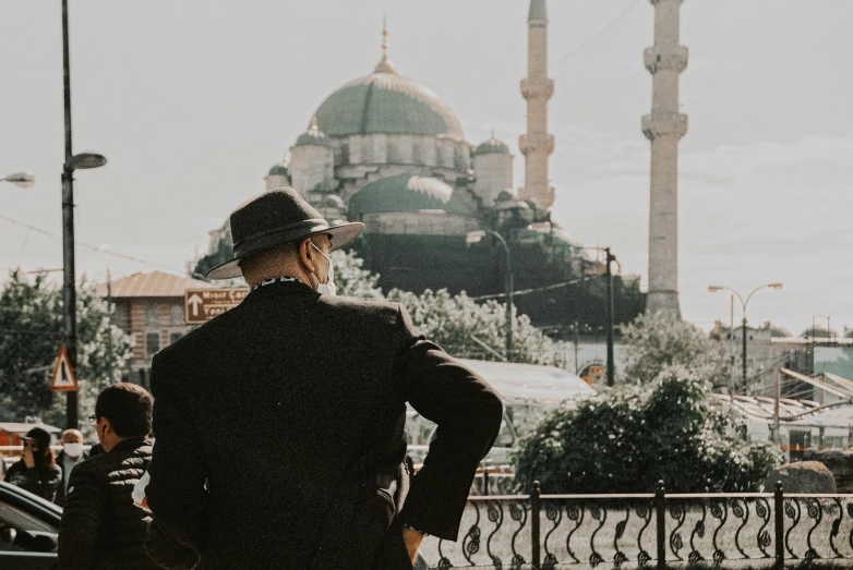 a man standing in front of a large mosque