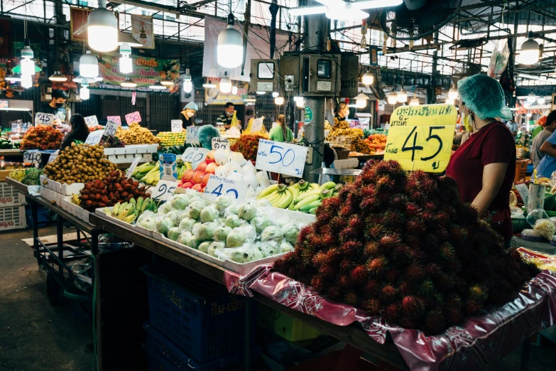 a person in a market standing by some fruit