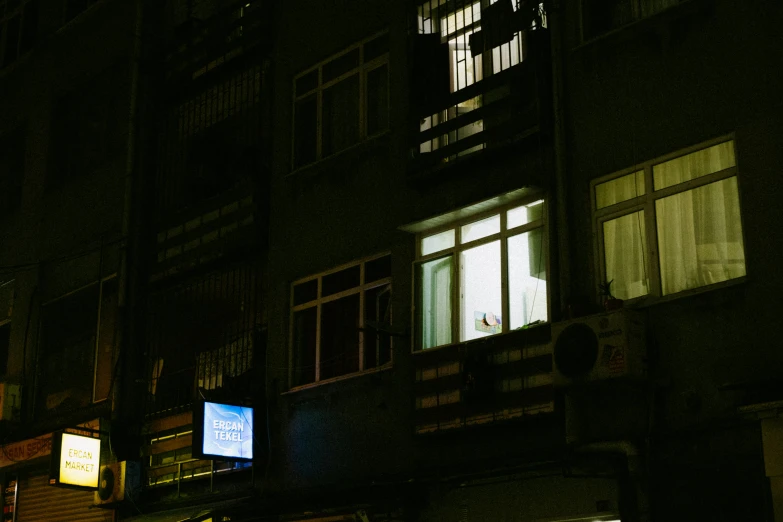 the city streets are illuminated at night by the building windows