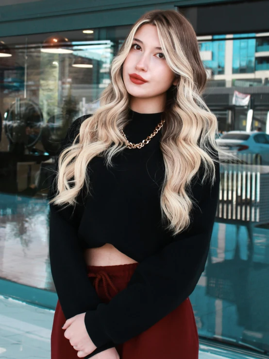a beautiful woman with long blonde hair and wearing black sweater