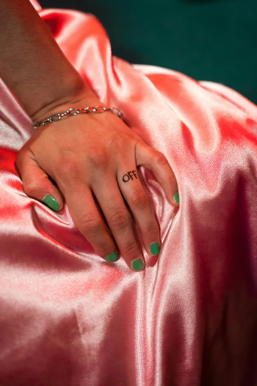 a female's hand wearing green nail polish