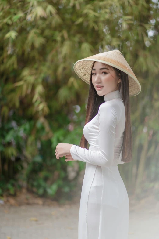 a beautiful woman in a white dress and large hat