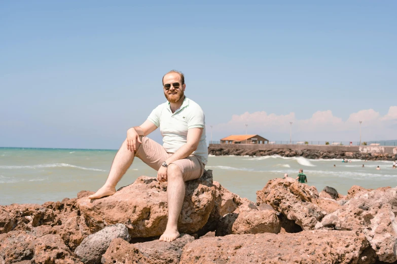 a man sitting on top of a large pile of rocks