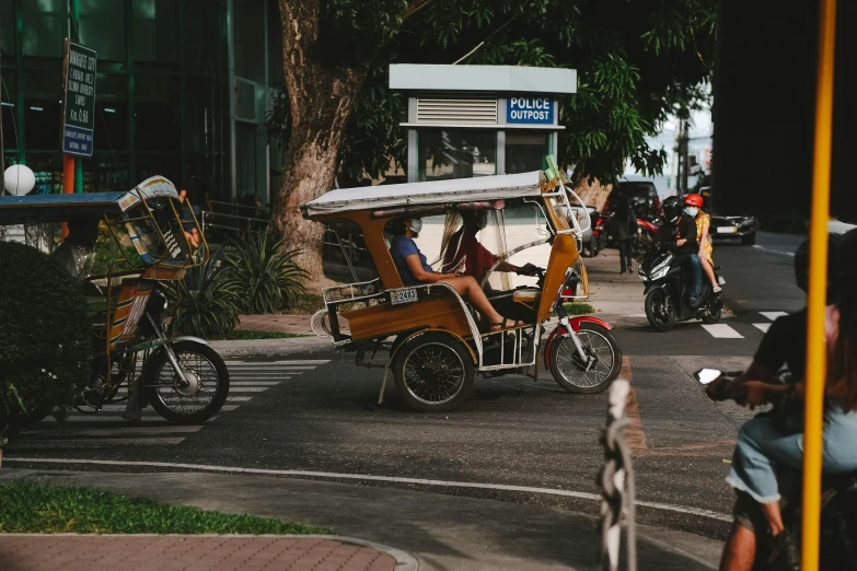 two men driving in a trike and holding a umbrella