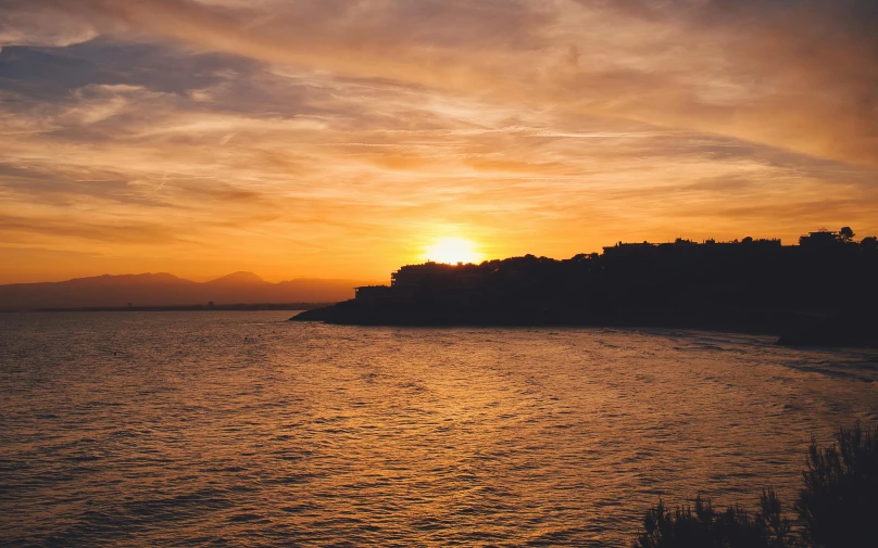 the sun is setting over some small island in the ocean