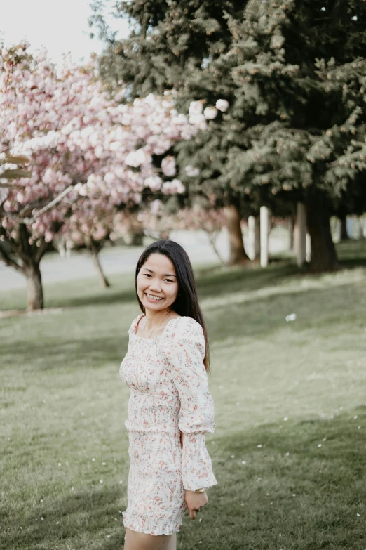 a girl poses on the grass in a park