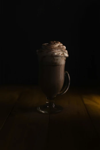 a glass filled with chocolate drink on top of a table