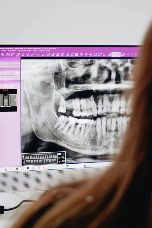 a person sitting in front of a computer monitor with teeth on the monitor