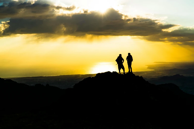 two people standing on a top of a large hill