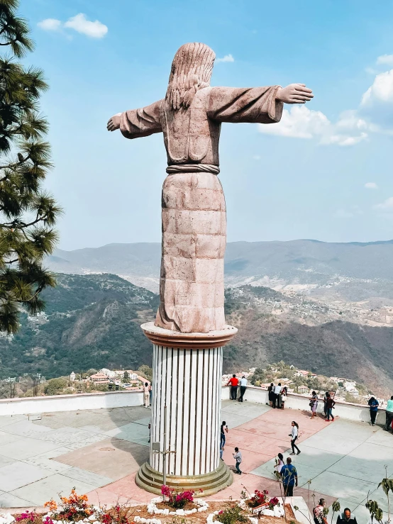 the large statue is next to a huge brick building