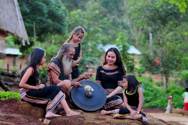 three indian women playing with a huge musical instrument