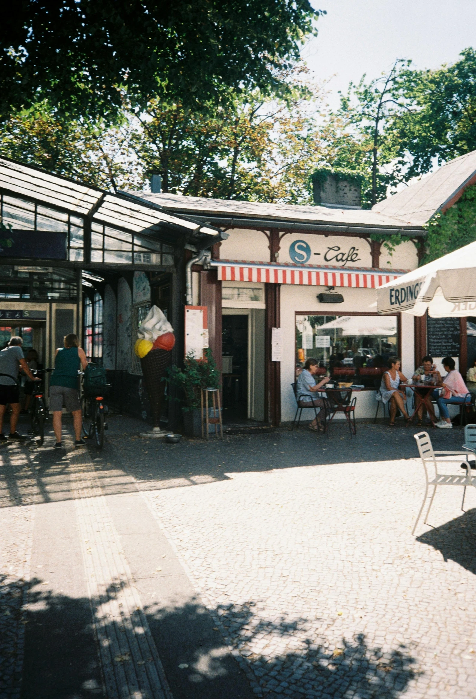 people at an outdoor cafe with large awnings