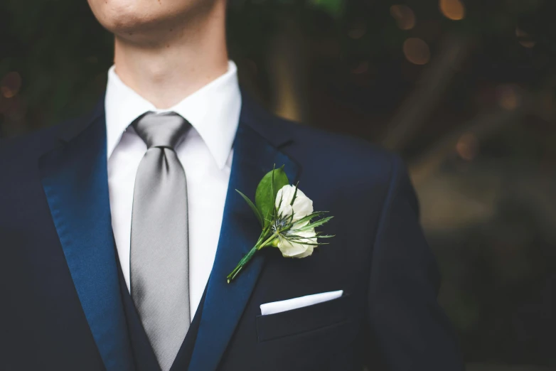 a man wearing a black suit and silver tie