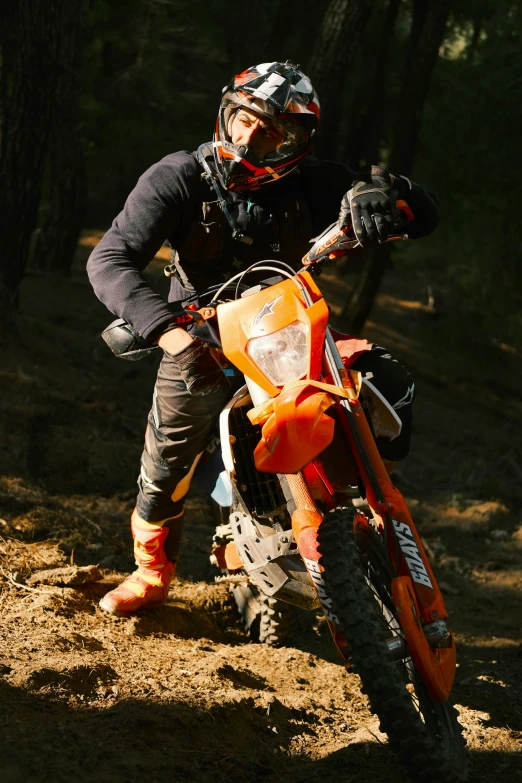 a motorbike rider sits in the mud with his bike