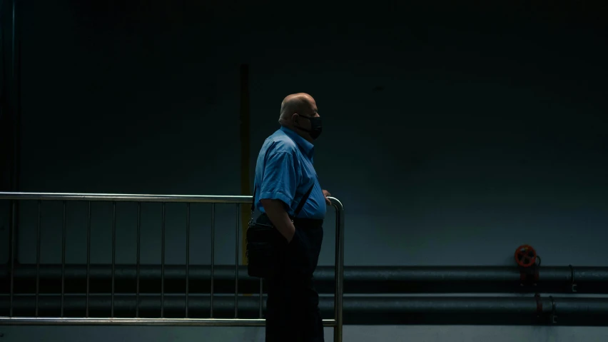 a man standing near a railing with a suitcase