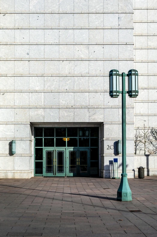 a street light with the lights on in front of an empty building