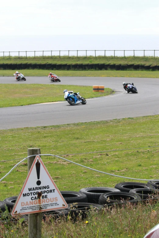 several people riding motorcycles in a race on a track