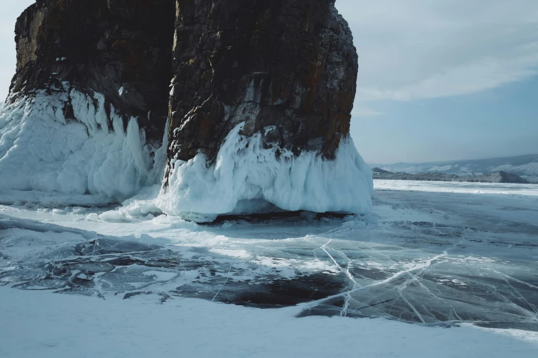 two tall tall rocks are on the shore of an ocean