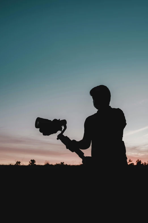 a man standing on a field with a camera