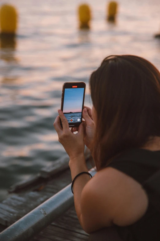 woman with long hair taking picture of dock