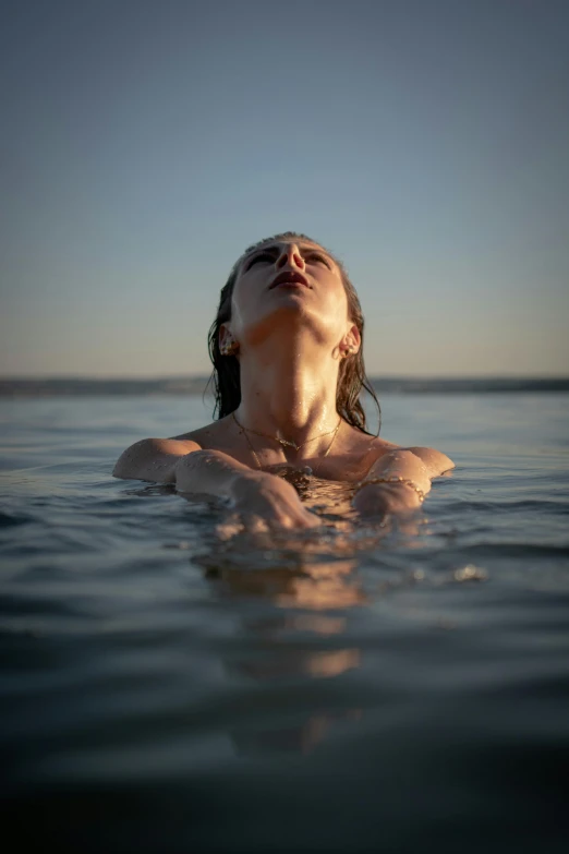 a woman in the water is looking up to the sky