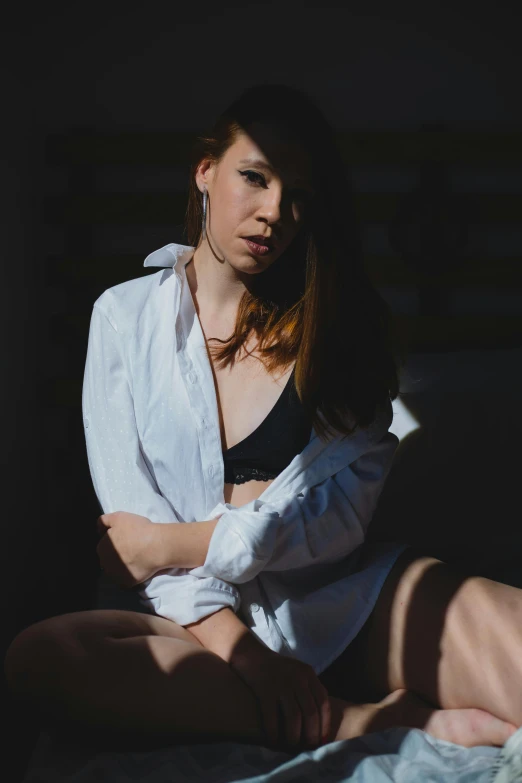 a woman is sitting on a bed posing for the camera