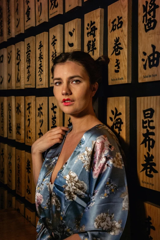 a woman standing in front of lots of framed asian writing