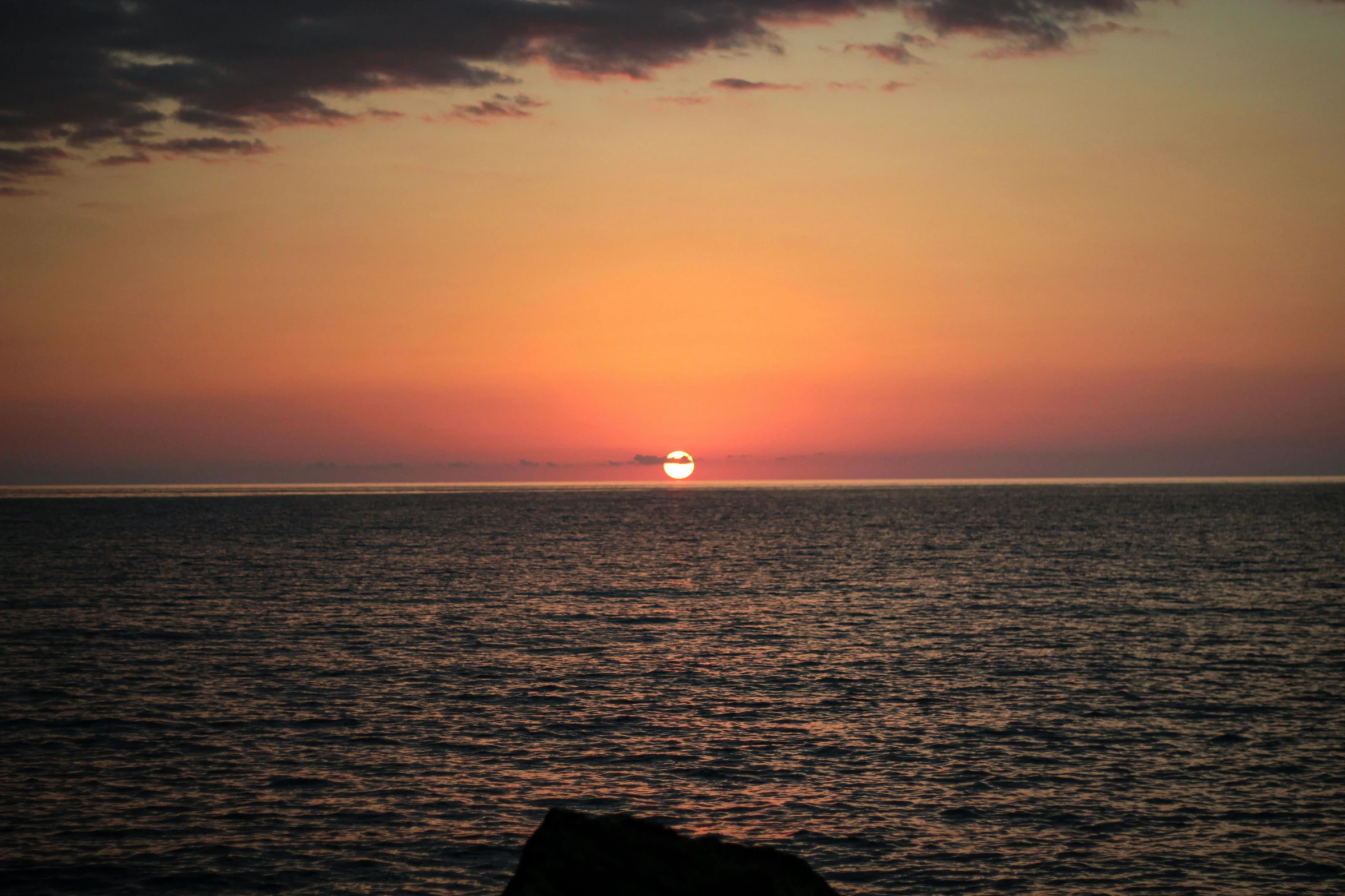 the sun is setting over water on the ocean