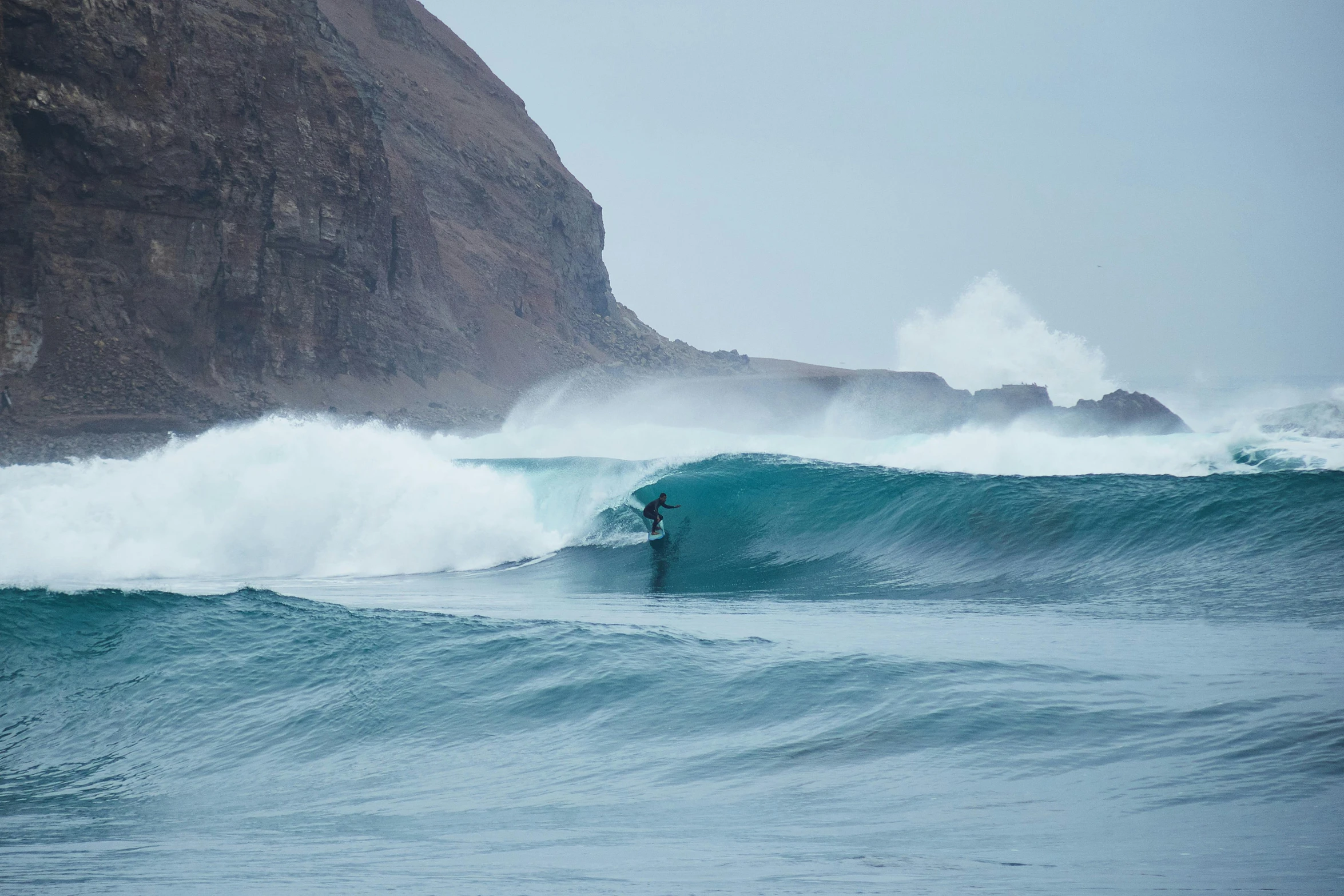 the surfer is riding the big waves into shore