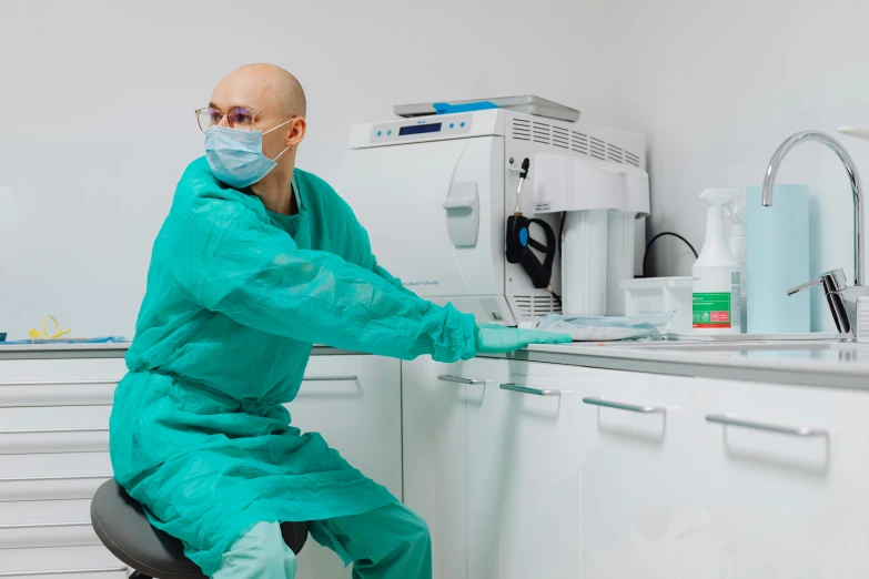 a man in a medical gown is working on a machine